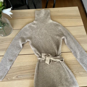 Stickad klänning - Stickad klänning från bubbelpool. En smalare modell med slits på benet. Aldrig använd, storlek S!  🤎