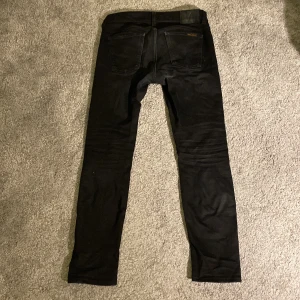 Nudie jeans - Säljer ett par Nudie Jeans i storlek w30 l30. Jeansen är slitna samt lagade på vissa ställen men överlag ger de ett bra helhetsintryck!