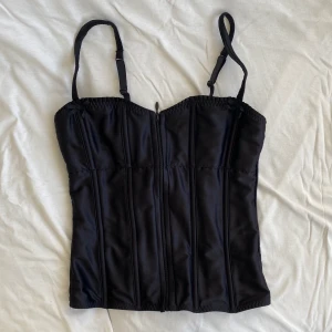 Korsett liknande topp  - Så snygg korsett likande topp med dragkedja fram och stretchig bak. Med små rosetter på banden som är justerbara. Mycket bra skick, inga deflekter. Säljer endast till bra erbjudande. Köps då via Swish (frakt 54 kr) eller köp nu 💋