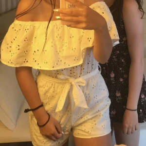 Vit ”mönstrad” jumpsuit - En vit jumpsuit i ett slags håligt/broderat material, samt band att knyta i midjan 😍 så fin off-shoulder med en bred vollang över bröstet och axlarna. I strl S men passa även XS. Minns ej vart den är köpt men så gullig, för liten för mig tyvärr 🥲