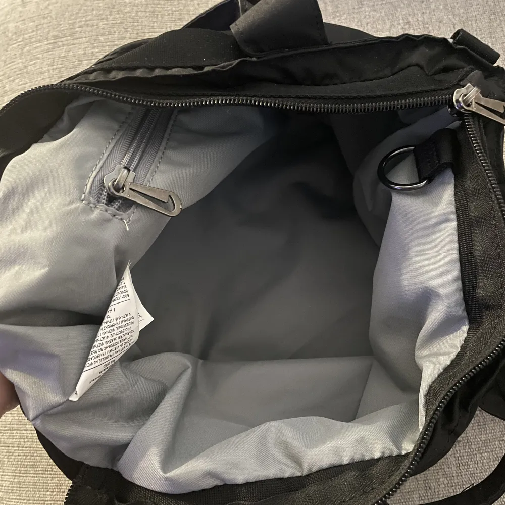 Säljer min nike väska som tyvärr inte kommer till användning. Den har coola detaljer och skön att bära och rymmer ganska mycket trots att den inte är så stor.  Knappt använt så den är som ny.  Återvunnet material är den gjort av och tål regn. . Väskor.