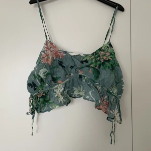 Topp - Sommartopp med knyte i sidorna så väldigt anpassningsbar. Man kan ändra banden över axlarna. 