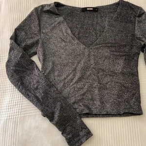 Glittrig topp - En superglittrig långärmad topp från Bik Bok i storlek XS. Stretchig och i väldigt bra skick. Köparen står för frakten.