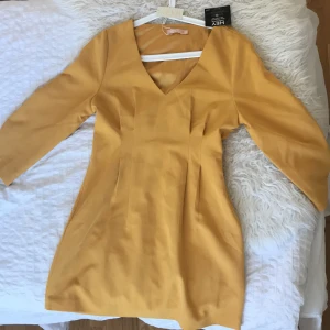Sprillans ny gul klänning - En senapsgul klänning som aldrig använts. Alla taggar är fortfarande kvar. Finns en dragkedja vid midjan vilket gör att den blir enkel att ta av och på.🤩
