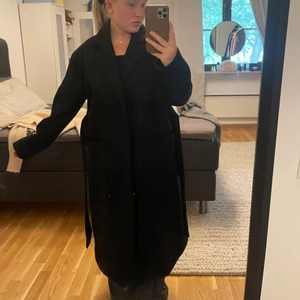 Lång kappa  - Lång svart ullkappa från Gina Tricot, knappt använd. Strl 36 men väldigt lång och rymlig. Köpare står för frakt!