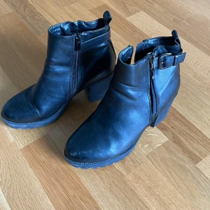 Boots med klack - Svarta boots med klack. I skinnimitation och med fodrad insida. Använda men fortfarade i gott skick