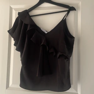 Topp med volang - Fin topp med volang. Knappt använd från NA-KD i storlek 36.
