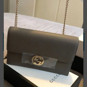 Gucci interlooking chain väska, grå färg - Helt ny äkta Gucci interlooking chain wallet , äkta läder och väldigt snygg. Fick den som present och den är köp från Italien, en av dem nya Gucci modeller som är väldigt populära. Ordinarie pris: 16,340 kr, säljer den för 7,499 kr. 
