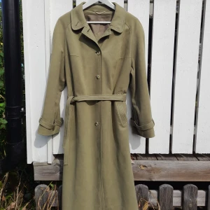 Olivgrön kappa - Alltså ! Hur fin olivgrön knälång kappa. Passar höst och vårväder. Nä men den är så fin men får inte tillräckligt mycket använding för den.