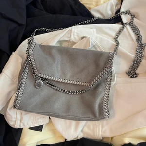Stella McCartney falabella ”crossoverbag” - Ljusgrå Stella McCartney väska i princip i nyskick då den bara är använd några gånger förutom en liten sminkfläck inuti på botten av väskan. Köpt på miinto för 6500kr