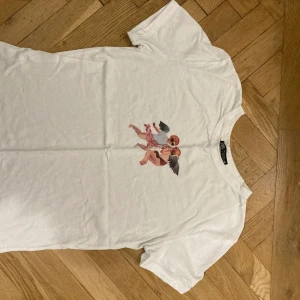 T-shirt från Zara med tryck  - Vit T-shirt med tryck på framsidan med två änglar. Den är storlek S men fuckar även i XS och M 