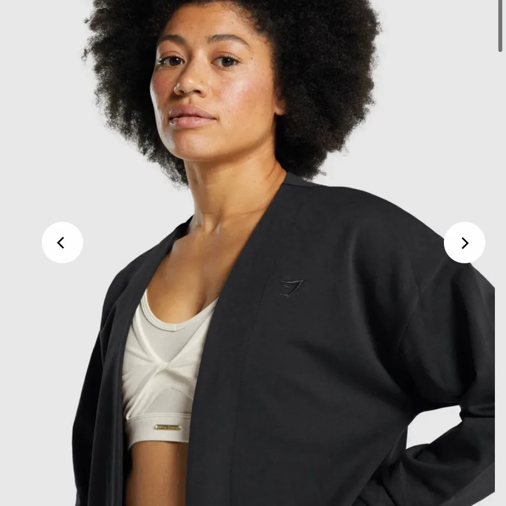 Whitney Oversized Robe i svart från Gymshark i storlek XS. Modellen från hemsidan har S på sig. Fint skick då den bara är använd ett fåtal gånger och den sitter oversized. Nypris: 599kr, mitt pris 300kr plus spårbar frakt på 66kr🖤. Tröjor & Koftor.