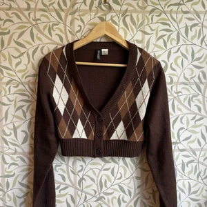 Stickad cropped kofta från H&M - Snygg cropped, mönstrad, kofta från H&M som kan kombineras med det mesta. Koftan har bara använts en gång och är i topp skick samt inte stickig!!! Fint att ha till en outfit en krispig höstdag! 