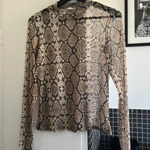 Genomskinlig Ormskins Tröja från Nelly - Jättefin topp från Nelly i märket NLY TREND. Den är väldigt genomskinlig och ursnygg med en snygg BH eller Bralett under! Perfekt för både sommar och vinter! 