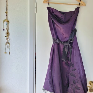 Klänning Fest Stl M - Mörklila fin festklänning, Vila stl M. Svarta broderade detaljer o tyll i nederkant. Svart a tagbart band i midjan.