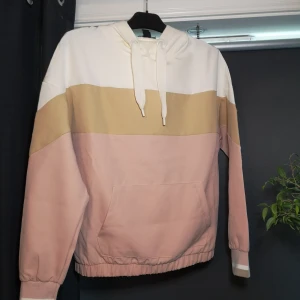 Hoodie - I färg av vit beige och rosa, den är i ett skönt material, använd fåtal gånger och är i nytt skick. En ficka på magen och luva med snören. Hör av dig🤘✨