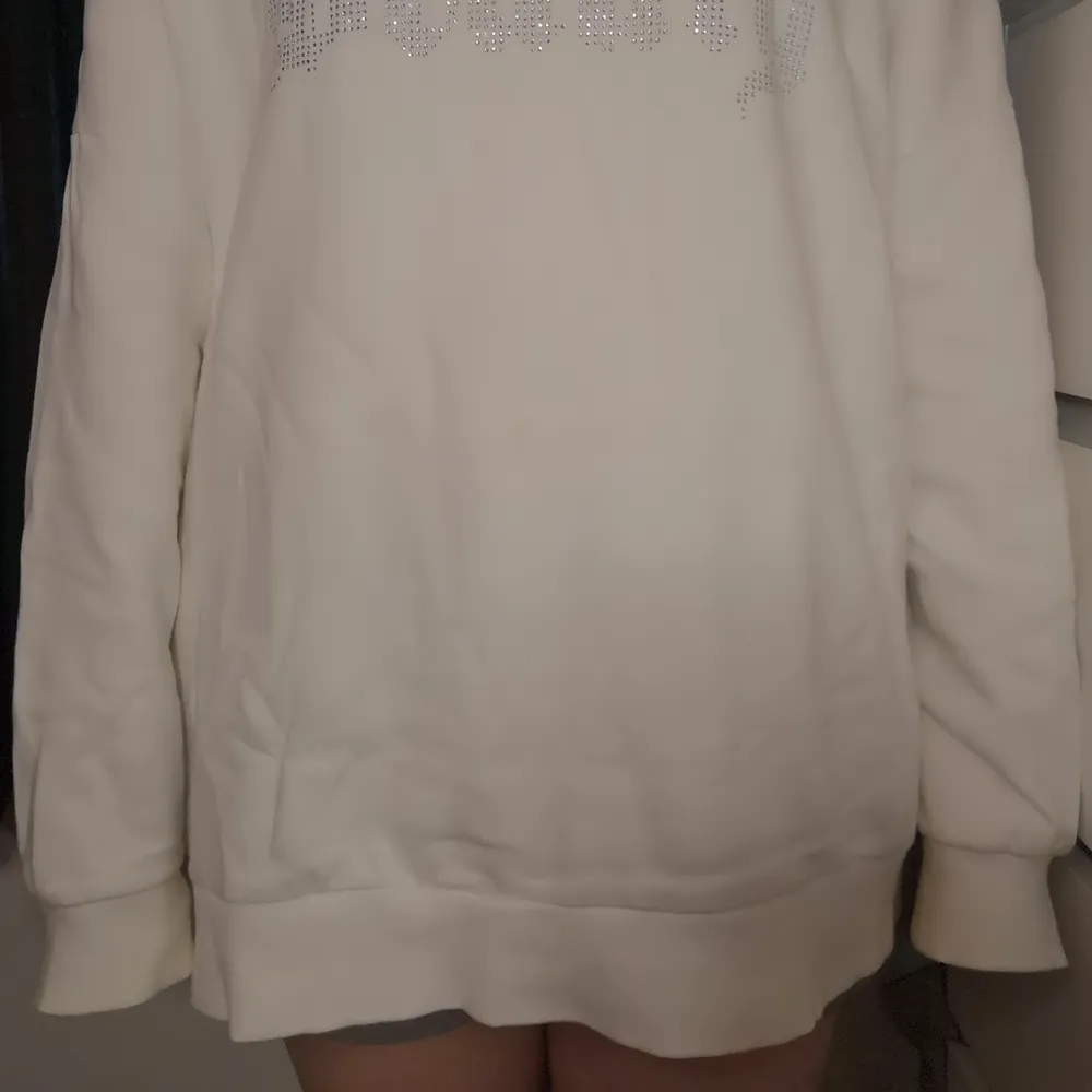 En vit skön hoodie/klänning. Det står skrivet 