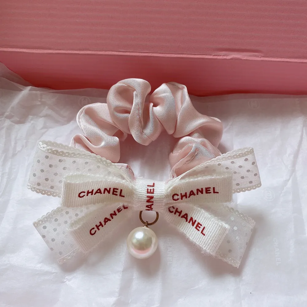Väldigt söt hårsnodd med rosett i vit och rosa färg. Äkta Chanel band. Kolla gärna mina andra annonser för söta/ fina små saker.  Frakten kostar 13kr . Accessoarer.
