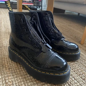 Dr Martens - Svarta, lackade Dr Martens Sinclair Plattform. Nypris 2400kr. Storlek 41, men passar mig som vanligtvis har 40. Har inte används mycket. Köparen står för frakt eller möts upp i Göteborg.