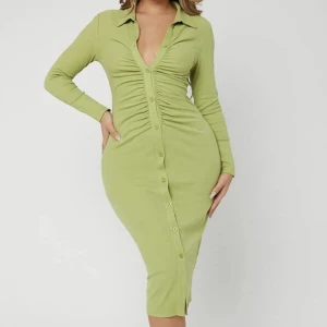 Grön midiklänning  - Grön midiklänning med knappar längst klänningen. Använd en gång och därför i väldigt fint skick!