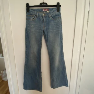 Low-waist jeans - Low waisted jeans i ljusblå färg. Mått: Midja - ca 34cm rakt över och hyfsat stretchig, innerben - ca 76cm. ( Går ej att få fitpic då plagget är för litet. SKICK: som nytt