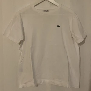 Lacoste T-shirt  - Vit Lacoste T-shirt   Storlek junior 16 ( passar dam xs-s )  Använd fåtal gånger så i toppen skick 