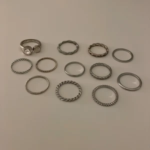 12 silvriga ringar i olika storlekar - Oanvända nästan allihop, 2-3 st har börjat tappa lite färg. Säljer då jag ej gillar att ha på mig ringar 