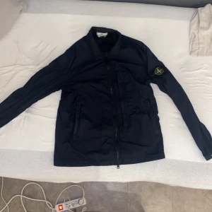Stone Island Overshirt - Säljer En marinblå/svart stone island overshirt. Tål vatten bra och kan användas ute och inne. Storlek S men kan bäras av M.