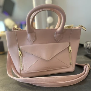 Söt väska - Ljusrosa väska med avtagbart axelband och guld detaljer. 