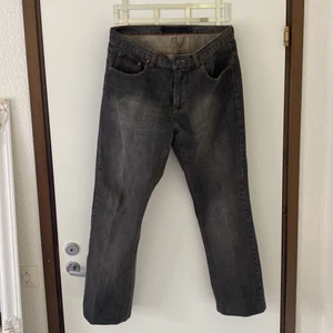 Jeans - Grå blåa slitna jeans men små röda detaljer på. Storlek M o sitter nice pösigt. Ganska långa också, går ner över foten på mig som är 173 lång. 