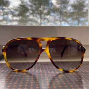 Alexander McQueen - Jättefina solglasögon! Något nötta men linserna är väldigt nära till felfria. Fina detaljer med strass i ögonen på dödskallarna. Fodral i användt skick medföljer. Modell AMQ4179