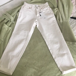 Vita jeans  - Helt oanvända jeans byxa.lappen sitter kvar på byxa . Storlek är xs Och är vida ben . Motett på midja är 35cm och längd på benen är93 och bred på lår är ca 28 cm.märke på byxa heter Fishbone sister . Undra ni mer om mått så bra skriv