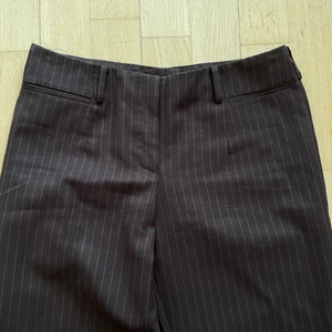 Lågmidjade bruna kostymbyxor - Lågmidjade bruna kritstrecksrandiga kostymbyxor! Jag har sytt in de så de passar mig som är en 36/38.