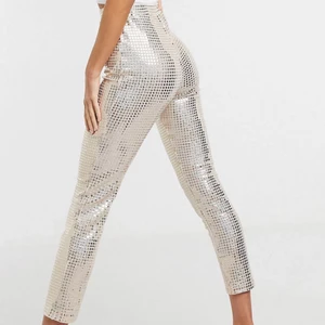 Glitterbyxor från ASOS st 40 - Riktigt coola byxor med skimrande paljetter i silver/rosé. Slappt material och resår i midjan 