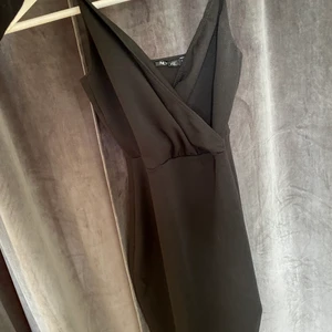 Svart tajt klänning  - Svart tajt klänning med omlott vid bysten. Från nellys egna märke 