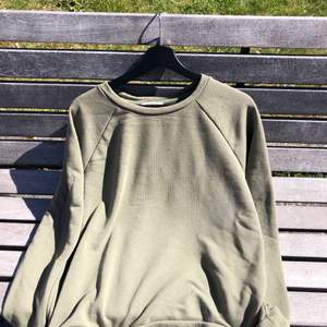 En mörkgrön sweetshirt i storlek XL. Tyget är något tunnare än på ”vanliga” hoodies så den är inte lika varm att ha på sig. Storlek M.