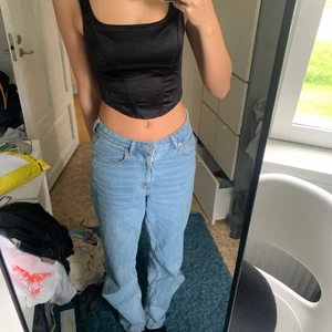 Svart korset liknande linne - Svart linne med sömmar så att det liknar en korsett. Ett lent tyg liknande silke. 