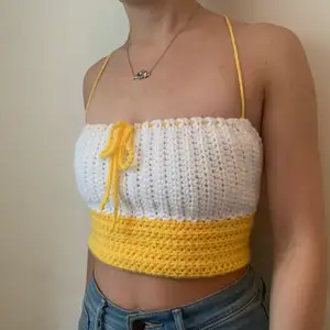 yellow and white handmade crocheted top. the lace-up back allows it to fit a variety of sizes, from XS to M. 💛🤍 100% acrylic yarn