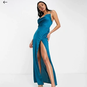 Saint Genies, långklänning st.38 - Blå långklänning i satin med draperad ringning fram. Helt oanvänd med prislappen kvar. Passar perfekt till bröllop, bal, studentskiva eller andra festliga tillfällen