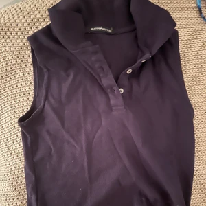 Croppad pike  - En pike utan ärmar i marinblå färg från Brandy Melville. Tröjan är croppad. 