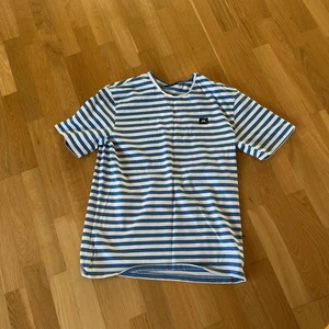 J.Lindeberg T-shirt strl M - Ljusblå och vit tshirt ifrån J.Lindeberg. Köparen står för frakt.