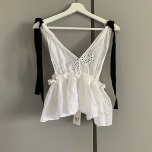 Vit topp med rosetter vid axlarna - Har två stycken, en i S och en i M