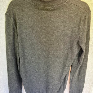 Oanvänd mörkgrå polotröja  - Säljer denna sköna polotröja i lite tjockare tyg. Ganska lång i halsen och perfekt i ärmarna