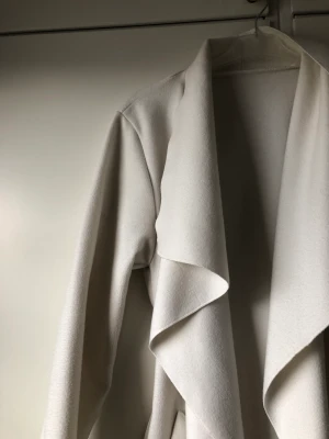 Vit kappa - En väldigt fin kappa som jag har använt en vår bara  Den passar till S-Väldigt mjuk och skön att ha 