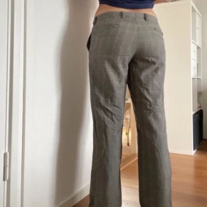 Lågmidjade kostymbyxor  - Lågmidjade kostymbyxor i grått med ett svagt rutigt mönster, står ej storlek men uppskattar till en 36/38 eller S💗
