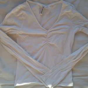Långärmad tröja - Långärmad tröja med drapering vid bysten från H&M. Strl xs. Aldrig använd, endast tvättad därav ingen lapp. Köparen står för frakt. 