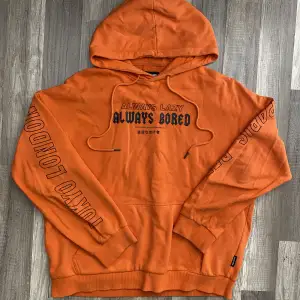 Orange hoodie med tryck, storlek M