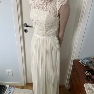 Vit långklänning  - Klänningen är använd en gång, så väldigt fräsch och vit. Den går hela vägen ner till fötterna på mig 168cm, men även på modellen 172cm. Stängs med en dragkedja och hake på sidan av klänningen. Köpt för 900kr.  Perfekt till studenten eller bal!