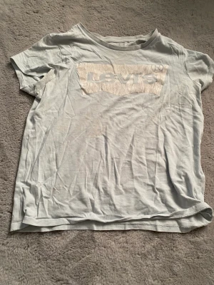 T-shirt  - Blå Levis t-shirt, använd många ggr, loggan har blivit lite förstörd efter tvätten. Skriv om ni har frågor och pris kan diskuteras :)