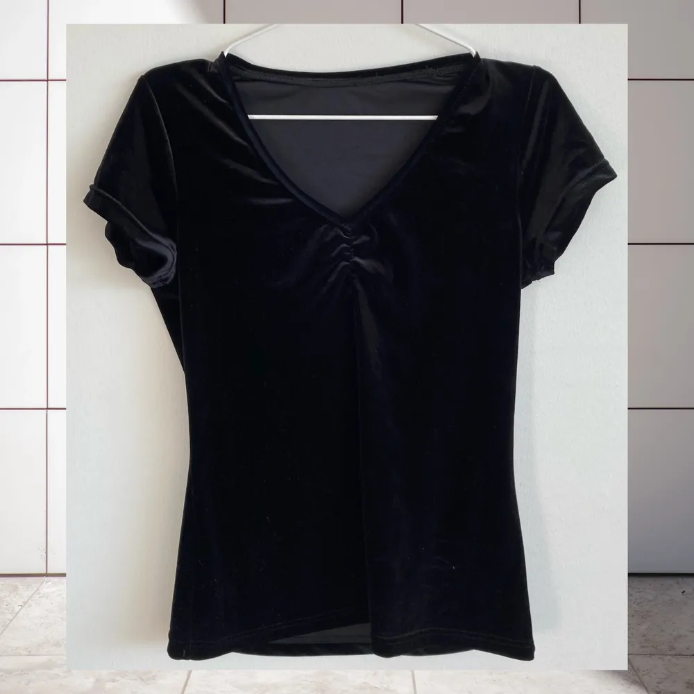 Basic svart t-shirt i sammets-tyg. Detalj fram, se bilder. Väldigt svårt att fota. Står ingen storlek, uppskattad till M/L. Tvättad men drar lätt åt sig damm på grund av materialet. Samfraktar gärna. Jag ansvarar inte för postens slarv.. Yläosat.